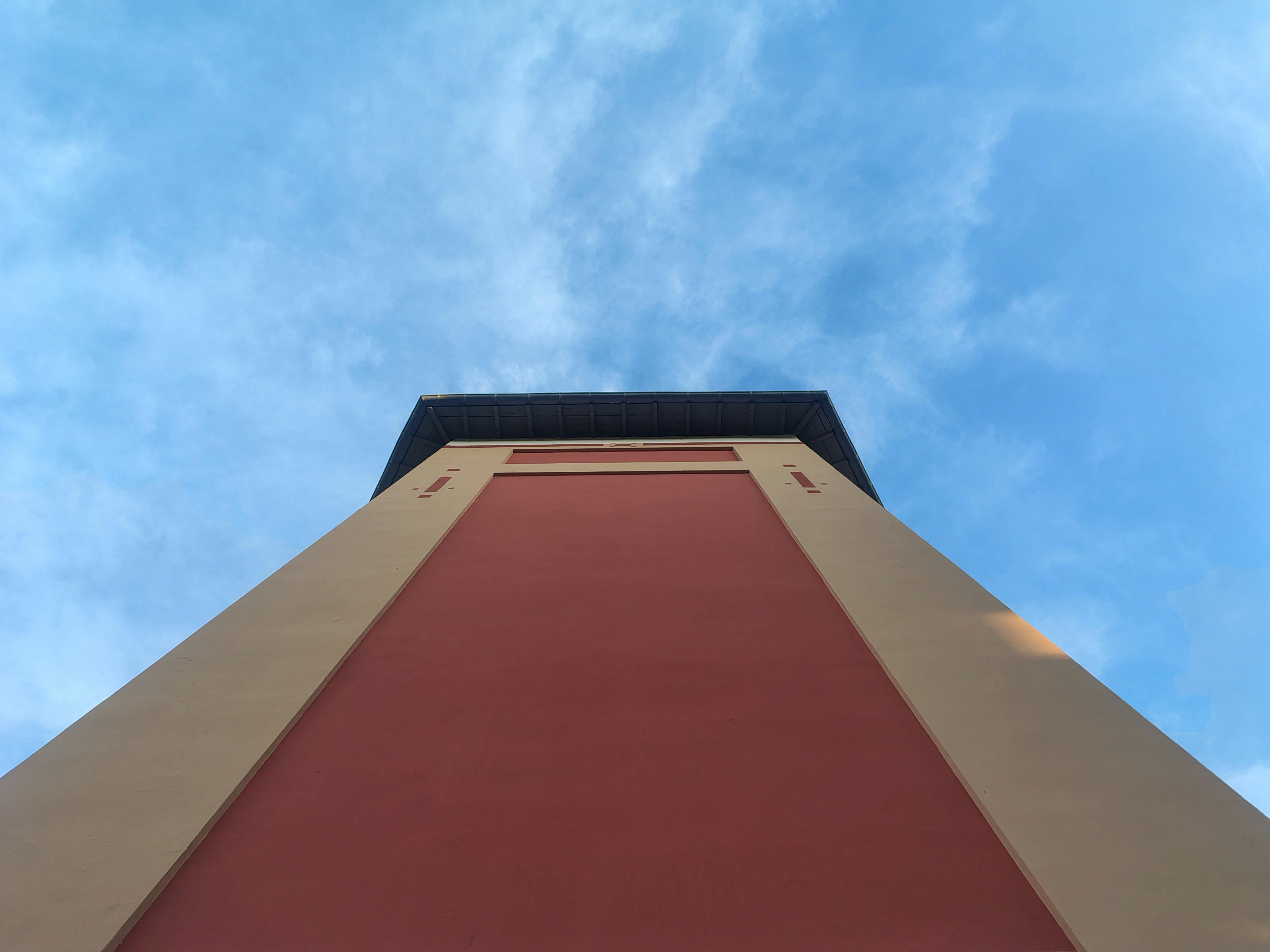 gratis Uitzicht vanaf boven op een kleurrijke toren tegen een helderblauwe lucht. Stockfoto