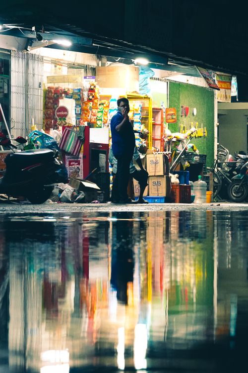 Free Captivating reflection of a vibrant street shop at night in Durgapur, India, showcasing urban daily life. Stock Photo