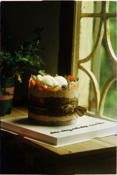 Celebrate with a rustic birthday cake illuminated by natural light from a window.