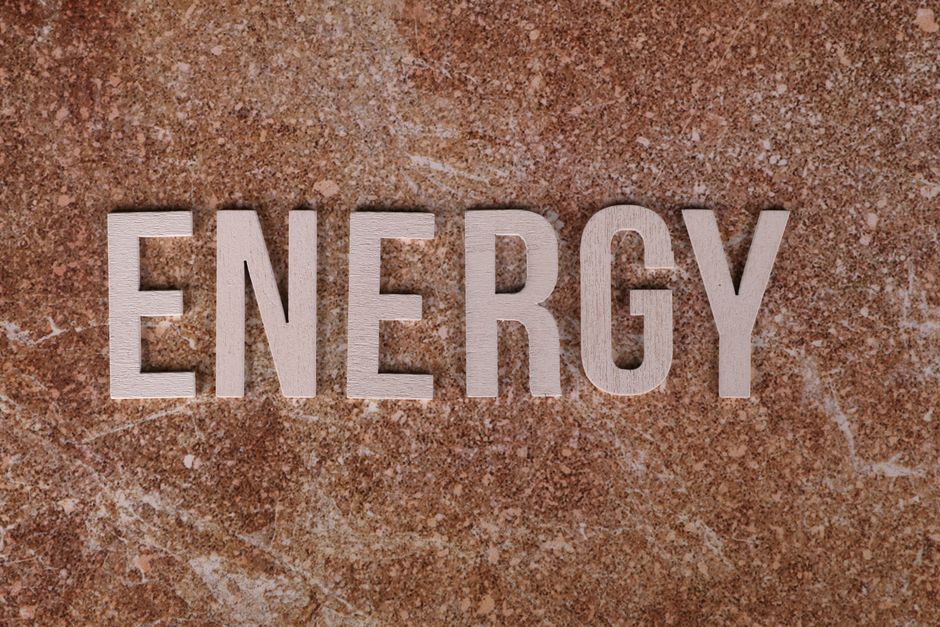 Word 'Energy' on natural stone texture, symbolizing raw power.