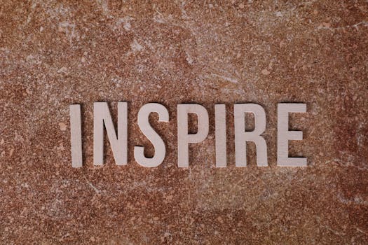 Inspirational word 'INSPIRE' on a textured stone background for motivation.