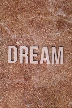 A word 'DREAM' crafted with bold letters on a textured marble background, symbolizing aspiration.