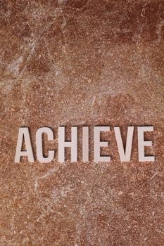 Motivational wall art featuring the word 'Achieve' on a textured background.