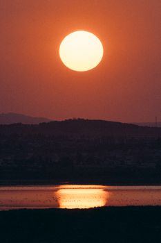 Beautiful sunset casting reflections over a lake in Tunis, Tunisia, creating a warm and serene landscape.