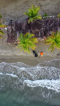 Aerial view of a person relaxing on the beach in Coveñas, Colombia, under palm trees.