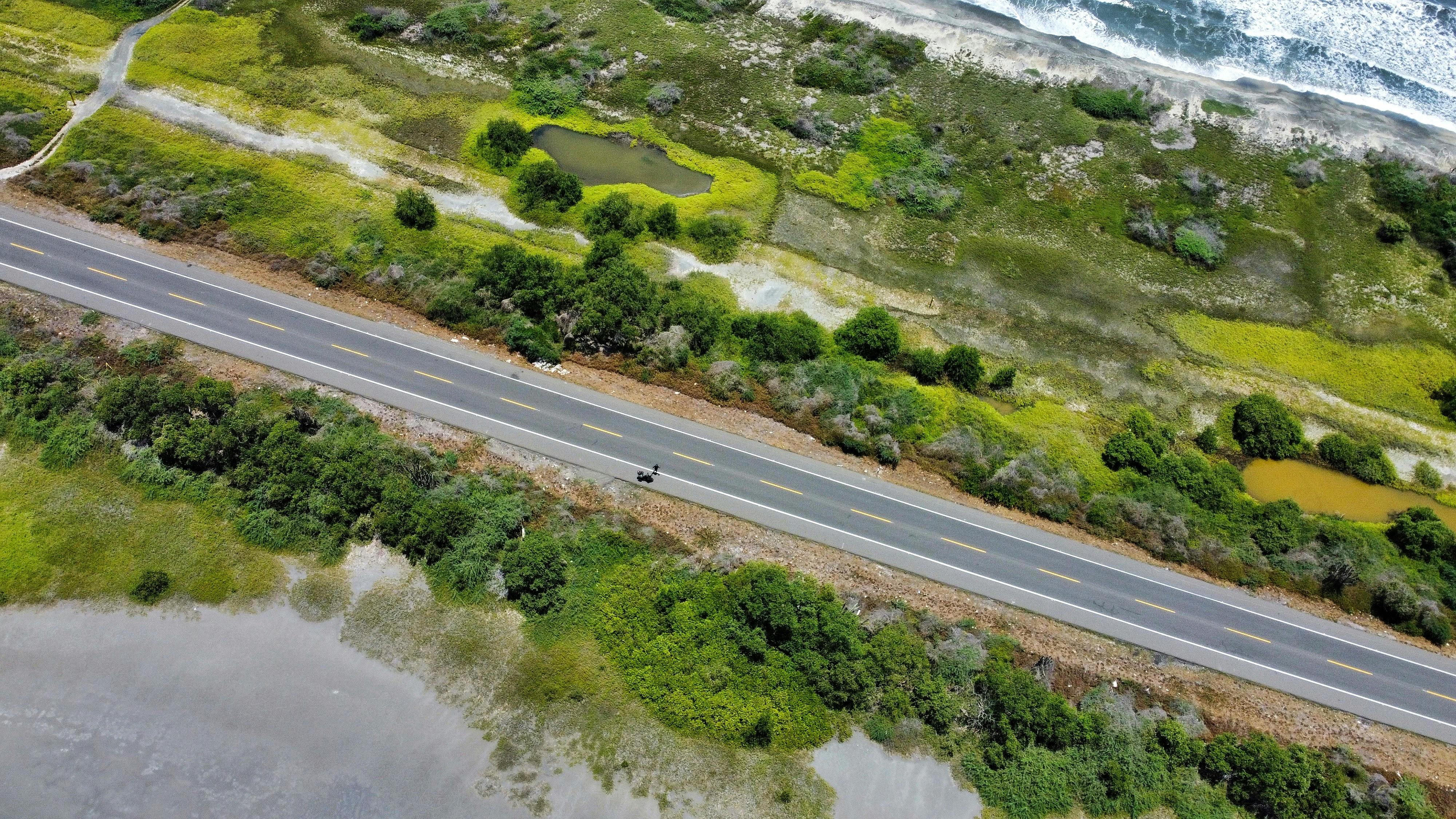 Aerial shot of lush coastline and road in Santa Marta, Colombia, showcasing natural beauty.