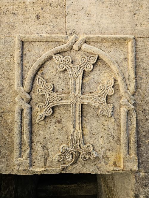 Free Detailed stone carving of a cross on ancient architecture with intricate patterns. Stock Photo