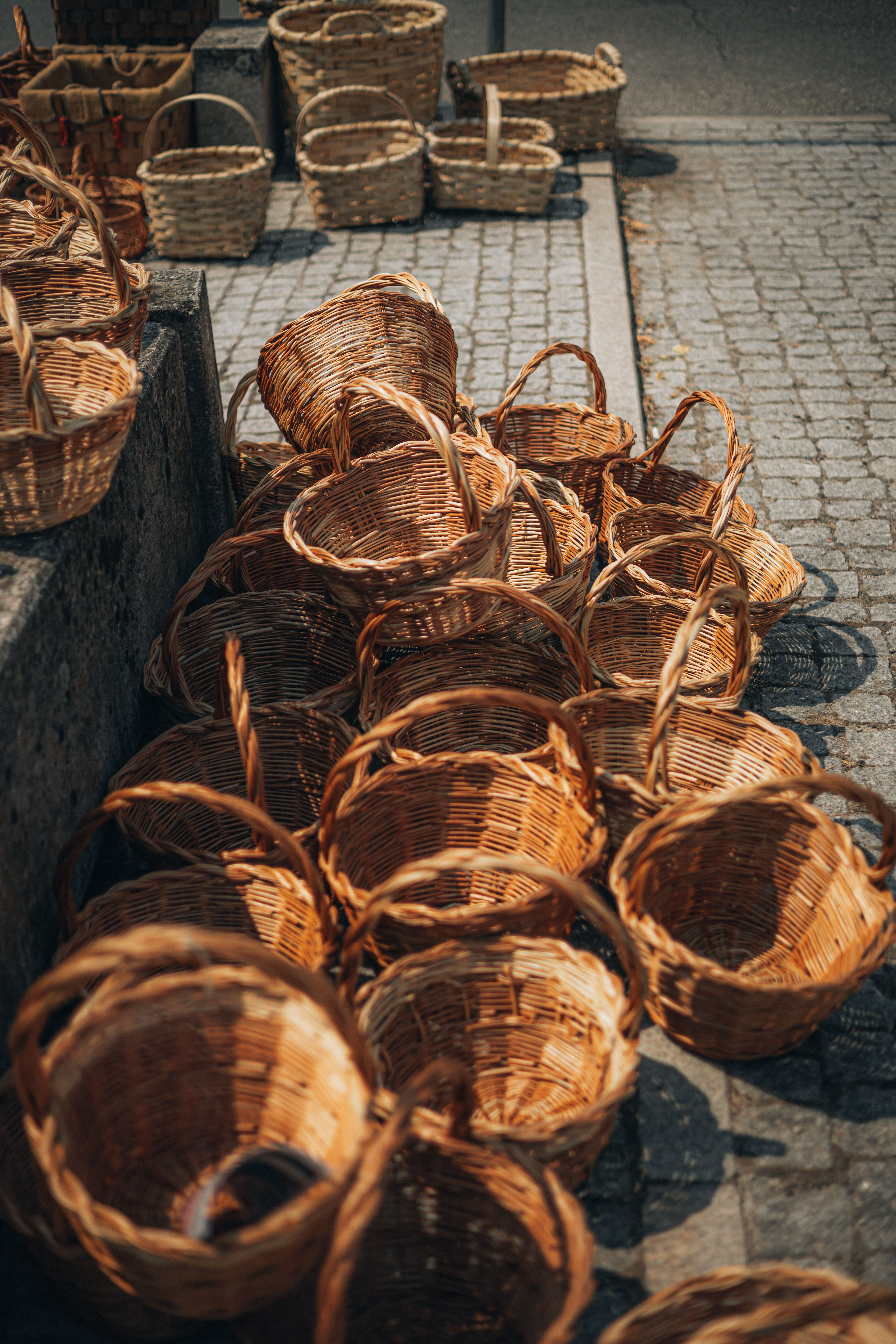 Handcrafted Wicker Baskets Display on Cobblestone Street · Free Stock Photo