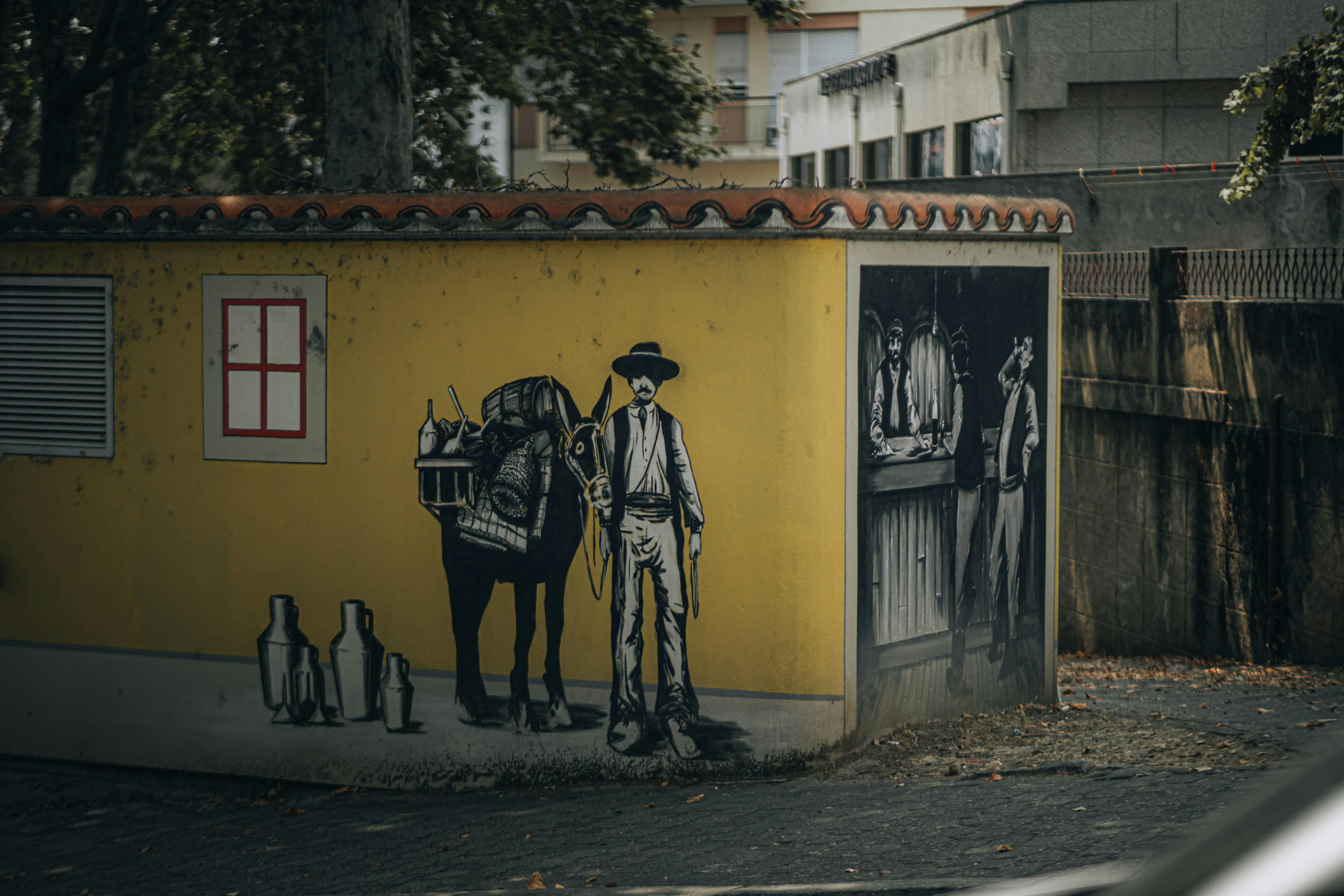 Kostnadsfria Utomhusväggmålning av en cowboy med en åsna och en saloonscen, som visar upp urban konststil. Stock foto