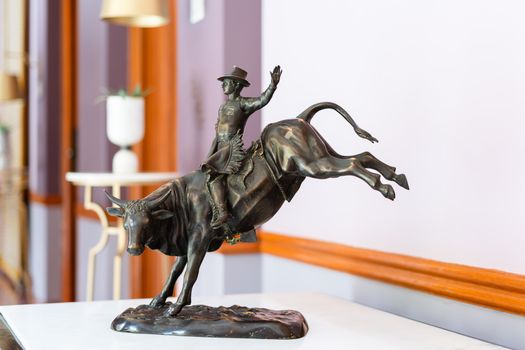 Bronze sculpture of cowboy riding a bucking bull displayed in a luxurious Rajasthan hotel.