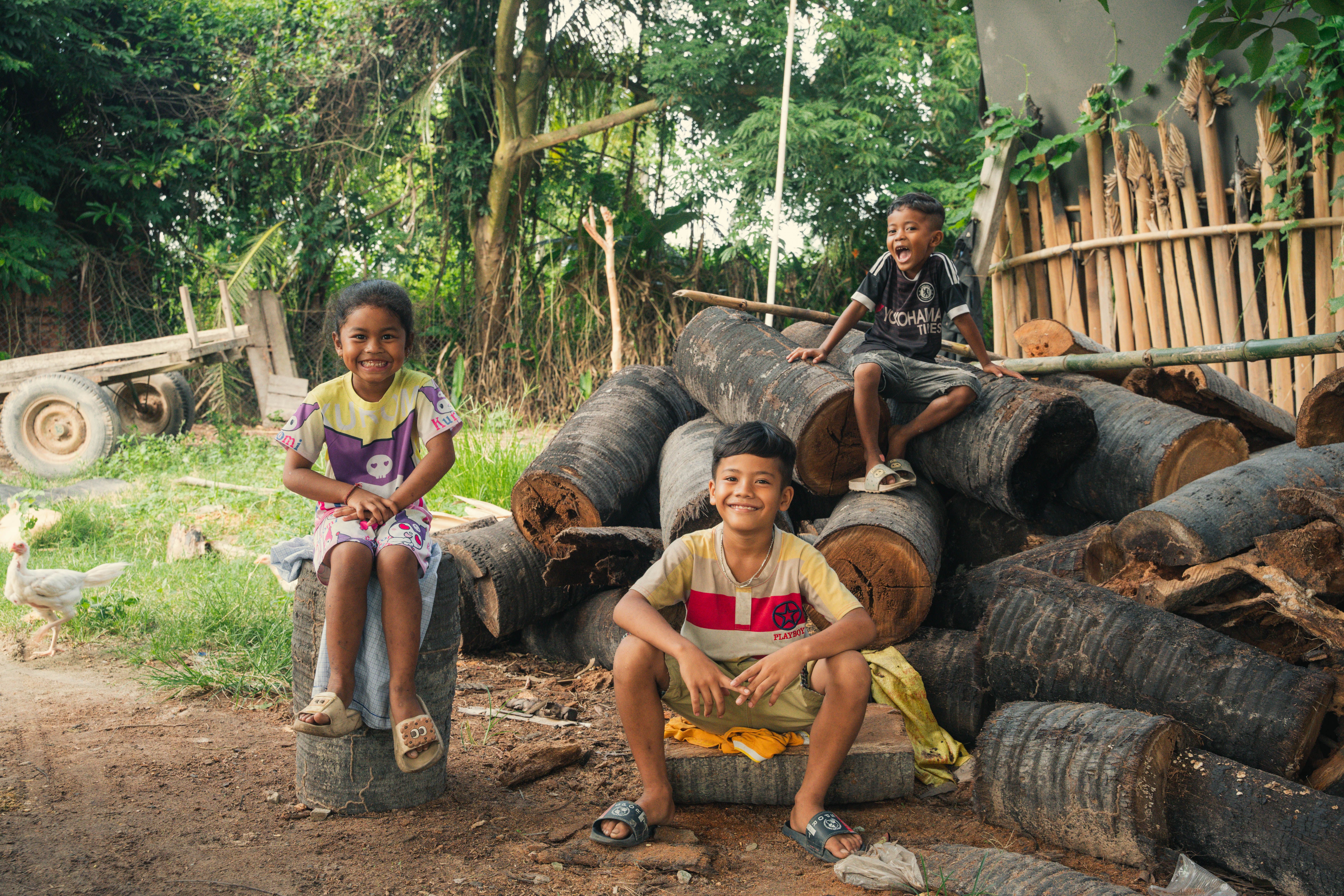 Smiling Children Playing Outdoors in Rustic Setting · Free Stock Photo