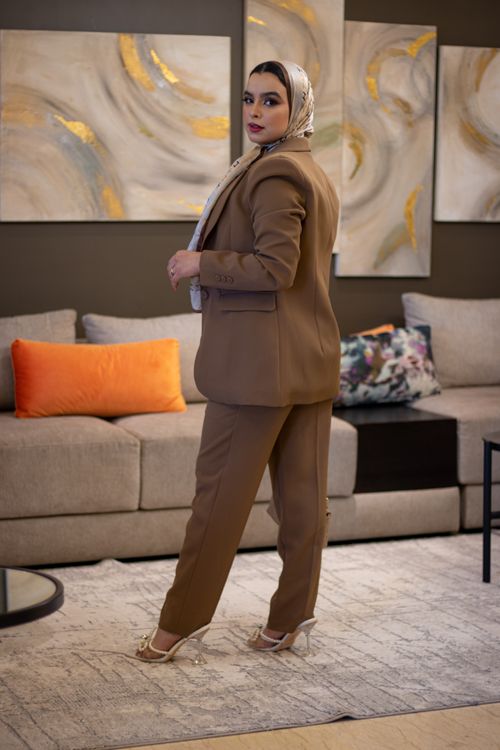 Free Elegant woman in a tailored suit poses confidently in a stylish living room setting. Stock Photo