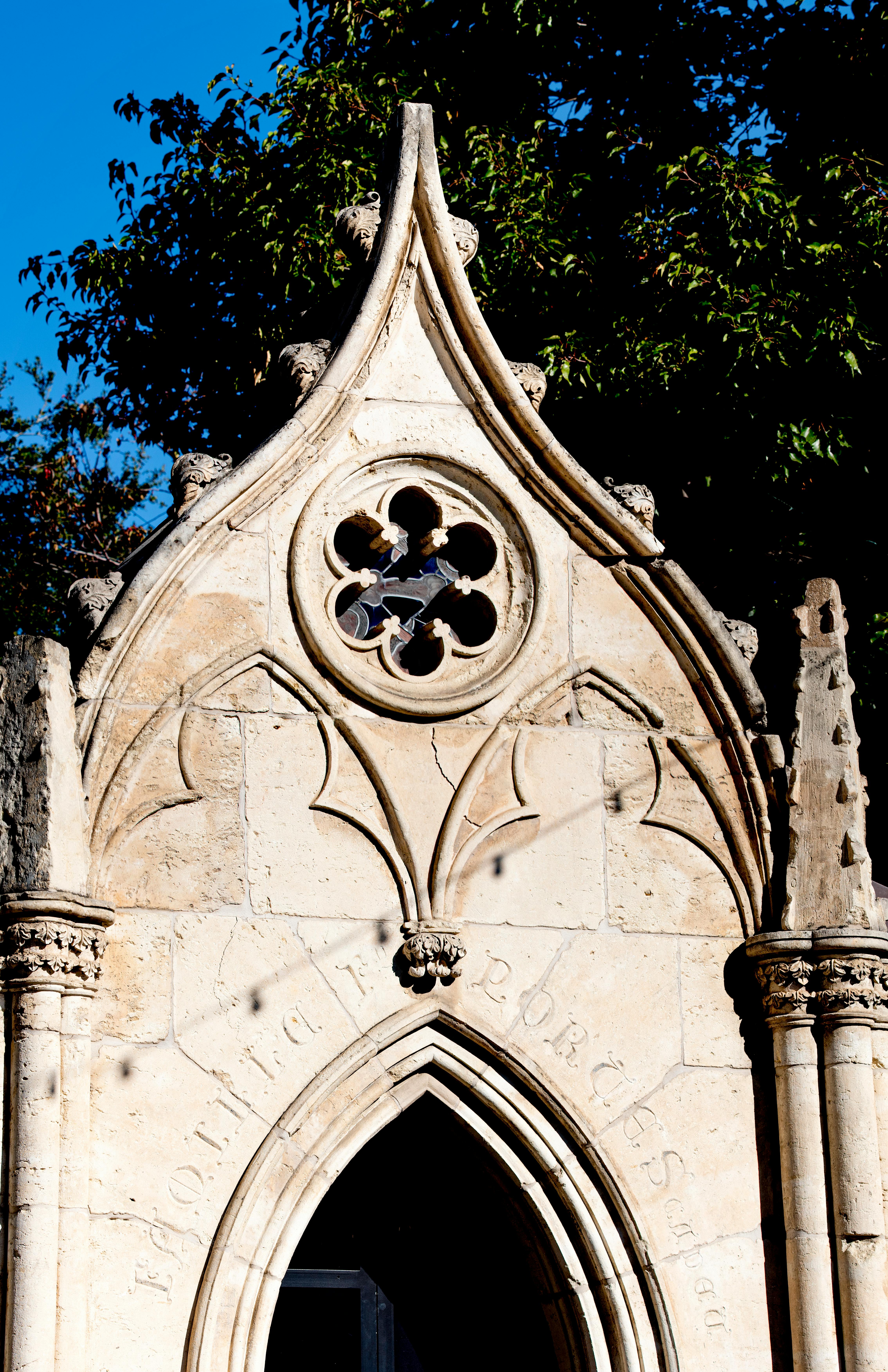 Detailed view of a gothic stone facade with intricate architectural design elements and afternoon light.