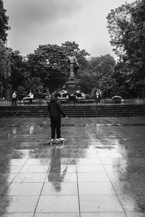 Free Street scene of a skateboarder in front of Ly Thai To statue in Hanoi, Vietnam. Stock Photo