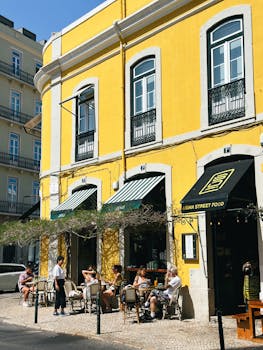 Yellow building with outdoor dining at an Asian street food cafe in Lisbon.