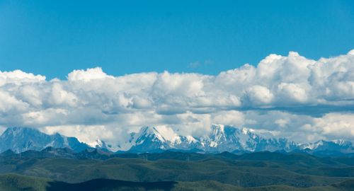 Free Snow-capped mountains under a bright blue sky with fluffy clouds, showcasing natural beauty. Stock Photo