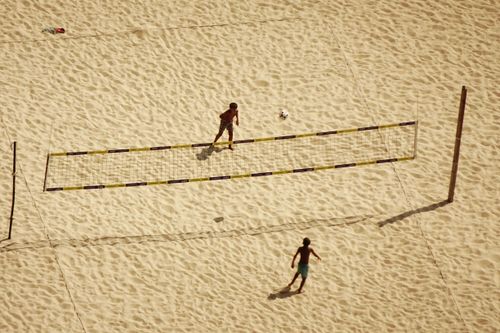Free Two people play volleyball on a sandy beach, viewed from above. Stock Photo