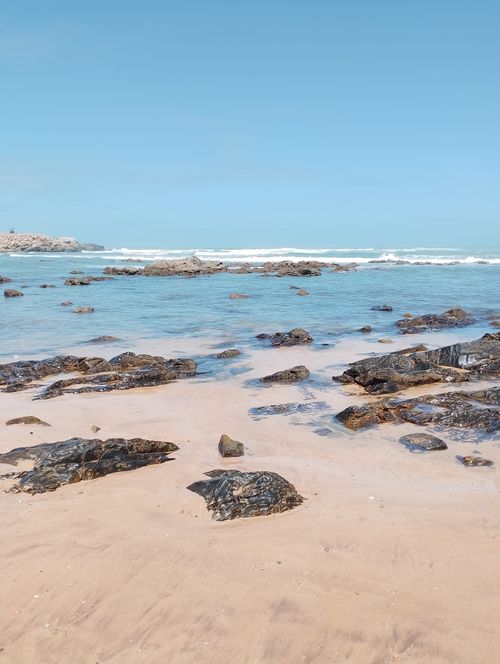 Free Peaceful sandy beach with rocky shoreline and gentle waves in Casablanca, Morocco. Stock Photo