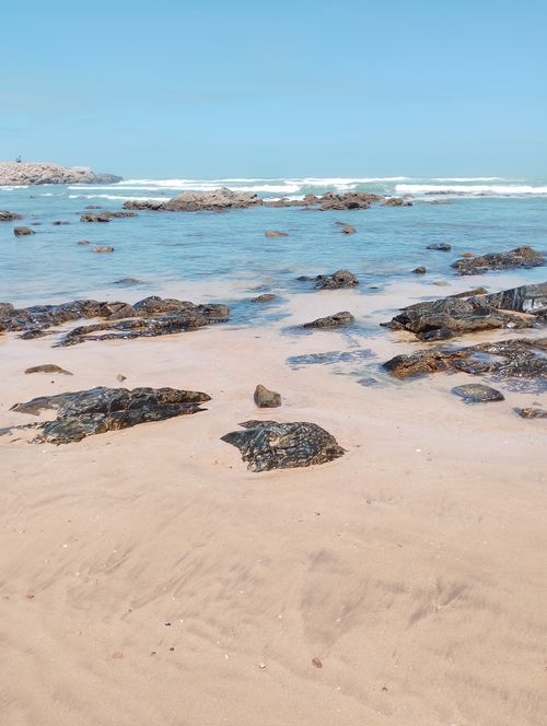 Free Serene beach scene in Casablanca, Morocco, showcasing clear blue waters and rocky coastline. Stock Photo