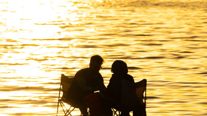 Silhouetted couple enjoying sunset by the sea at Yalova beach, Türkiye.