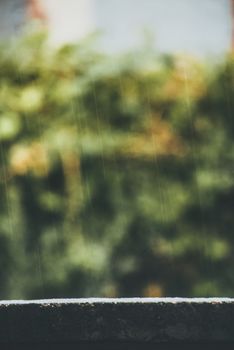 Close-up of raindrops falling with a blurred green background creating a serene atmosphere.