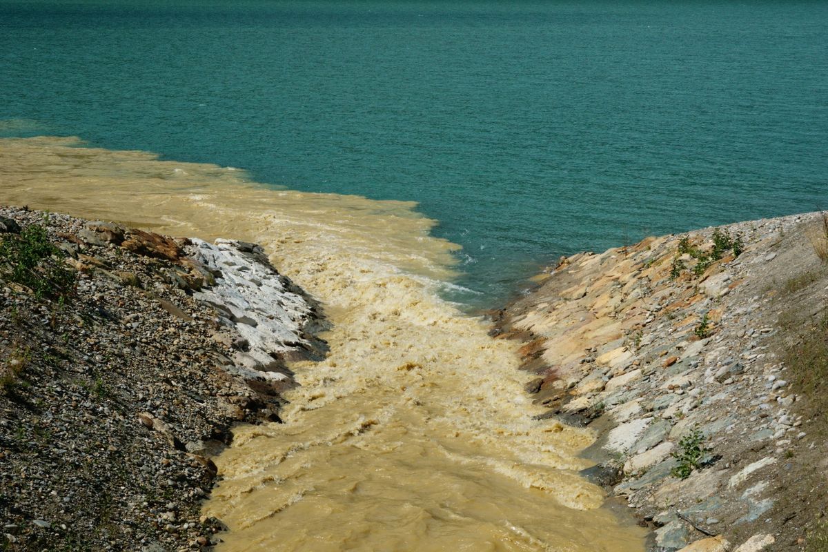 Two rivers merging at a rocky riverbank