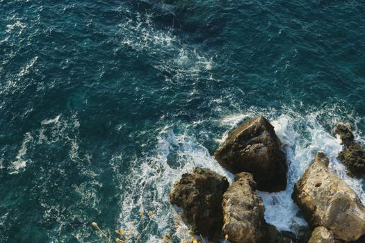 A beautiful aerial shot of crashing waves against rocks in the Adriatic Sea near Italy, perfect for travel and nature themes.
