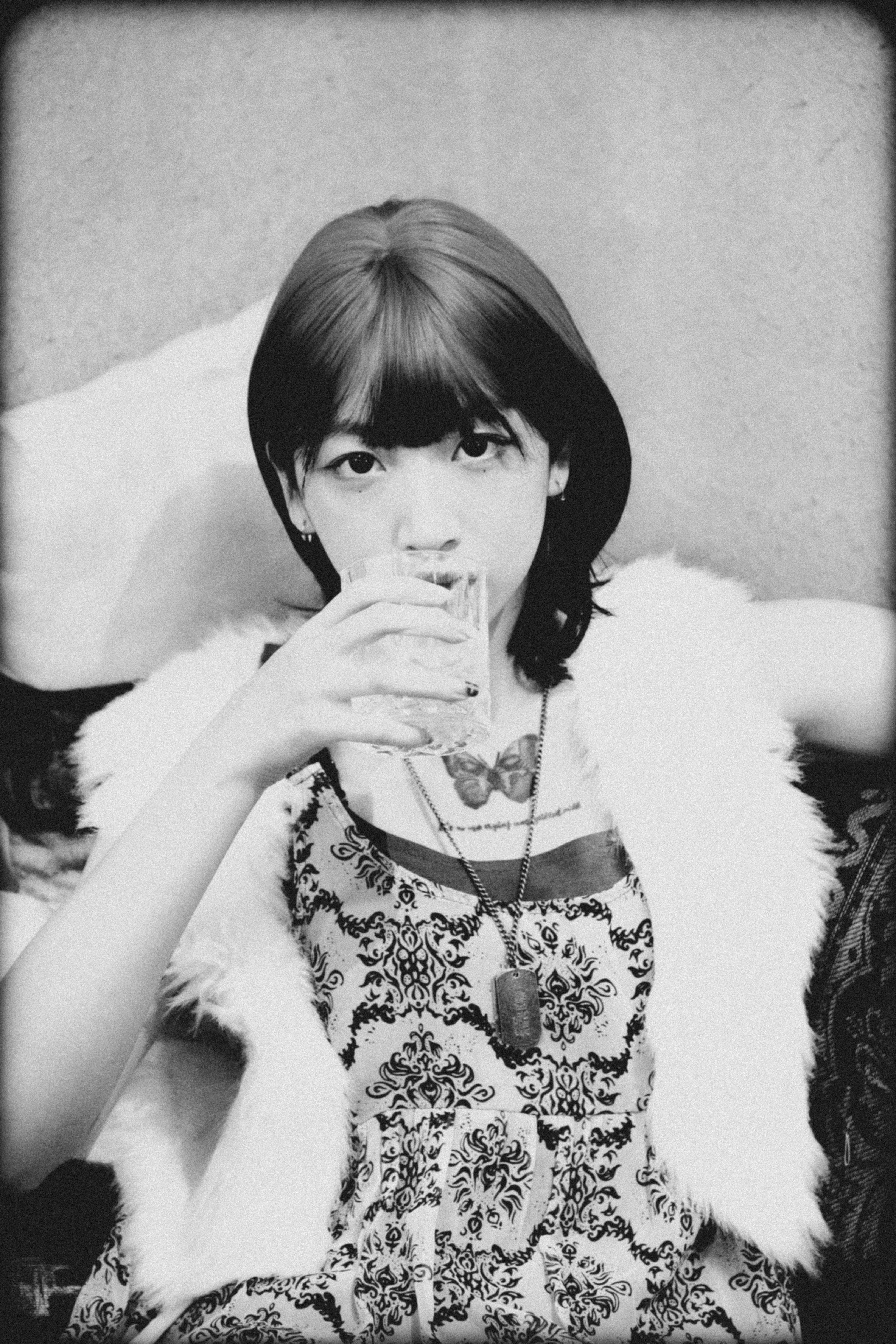 Ilmainen Taiteellinen mustavalkoinen muotokuva naisesta juoma kädessään, joka herättää vintage-estetiikkaa. Kuvapankkikuva