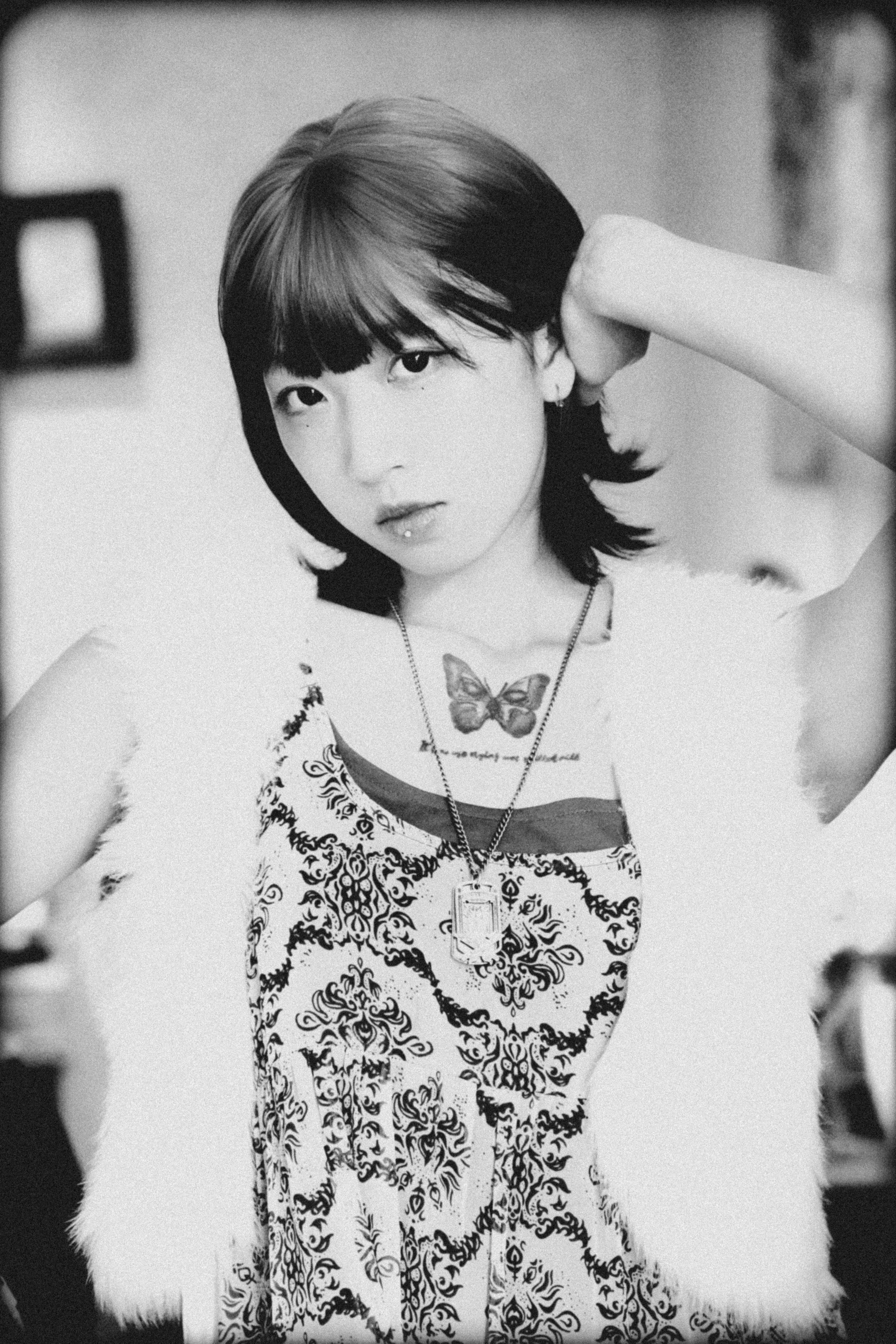 Gratuit Portrait expressif en noir et blanc d'une femme avec un tatouage de papillon. Photos