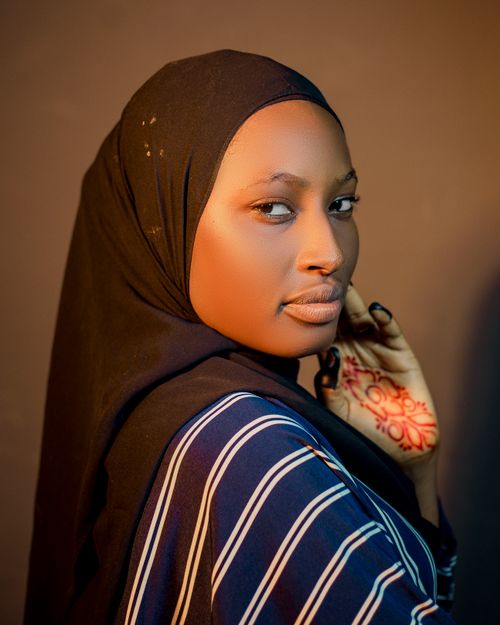 Free Beautiful portrait of a woman in a hijab with henna tattoos, serene expression. Stock Photo