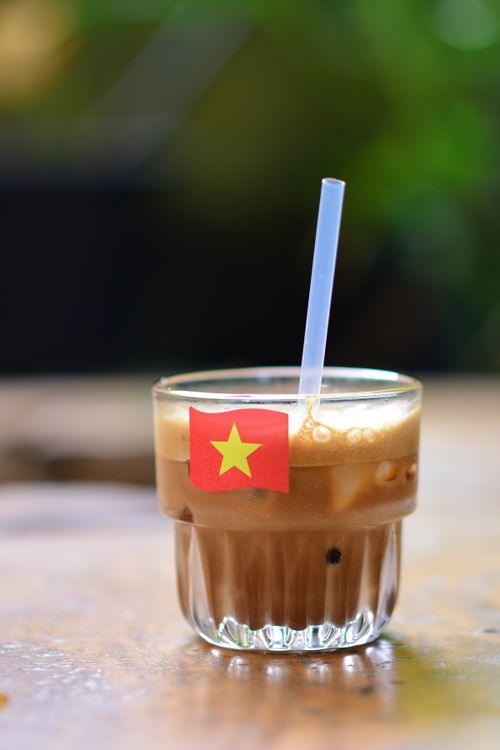 Free A refreshing glass of Vietnamese iced coffee with a small flag, ideal for coffee enthusiasts. Stock Photo
