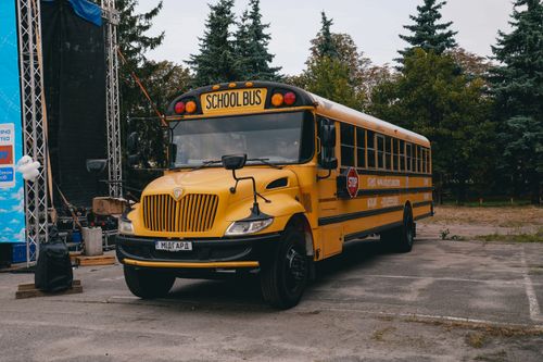 Free A classic yellow school bus parked at an event in Kyiv, showcasing a unique cultural twist on a familiar icon. Stock Photo