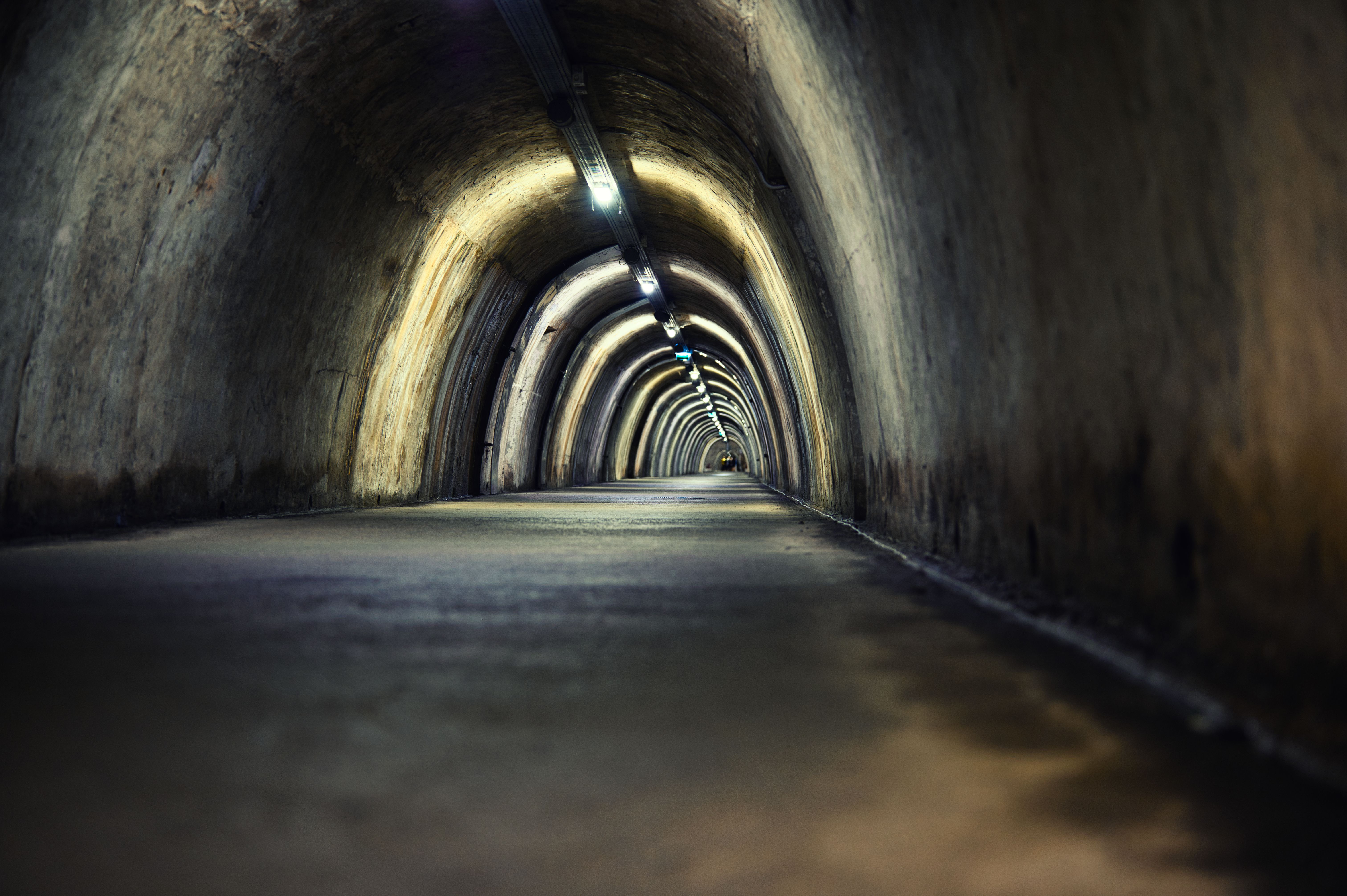 Mysterious underground tunnel with arched lights creating a moody atmosphere.