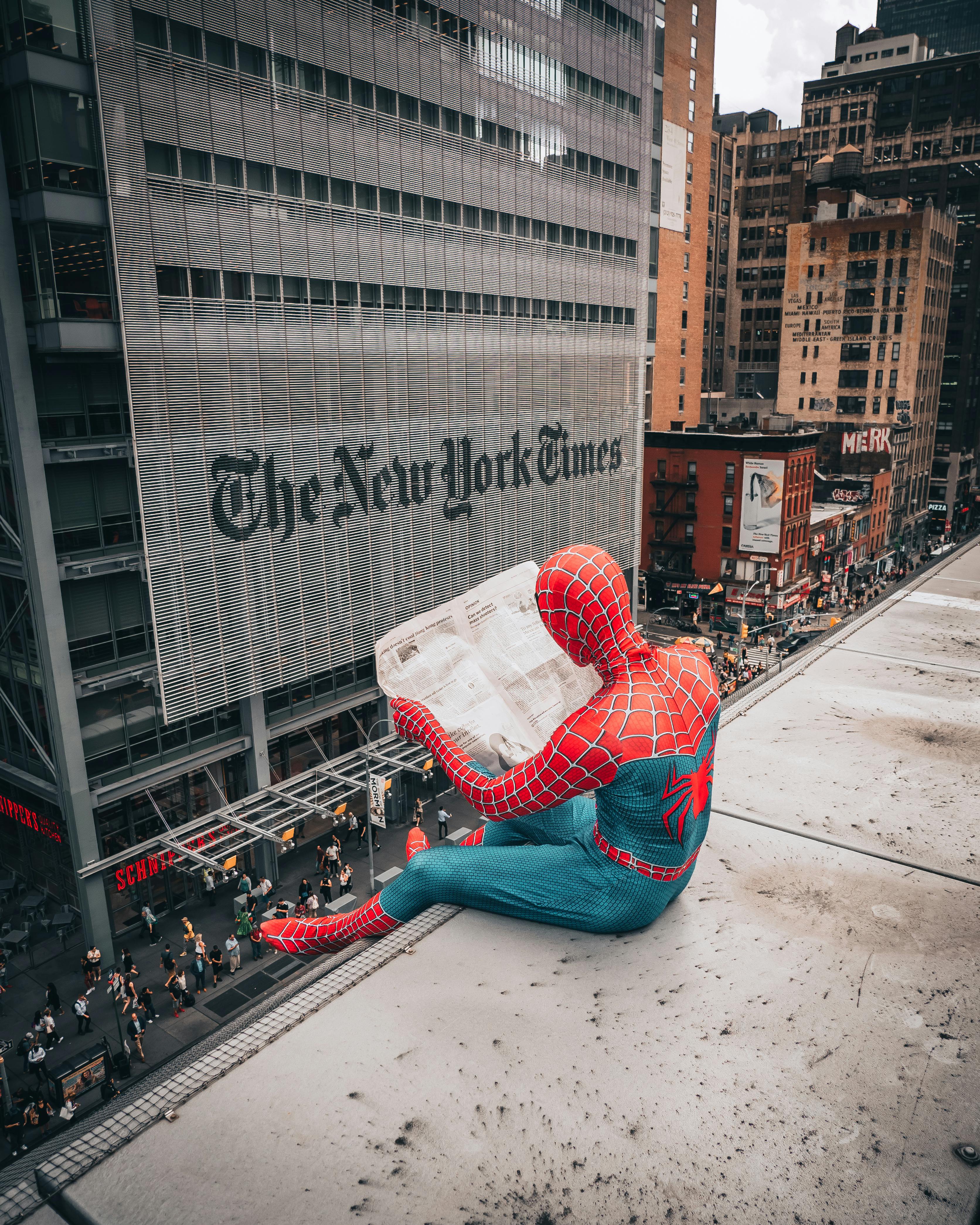 Spiderman Reading Newspaper on Top of Building