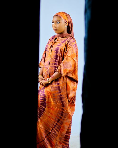 Free Portrait of an elegant woman in vibrant African attire with a serene backdrop. Stock Photo