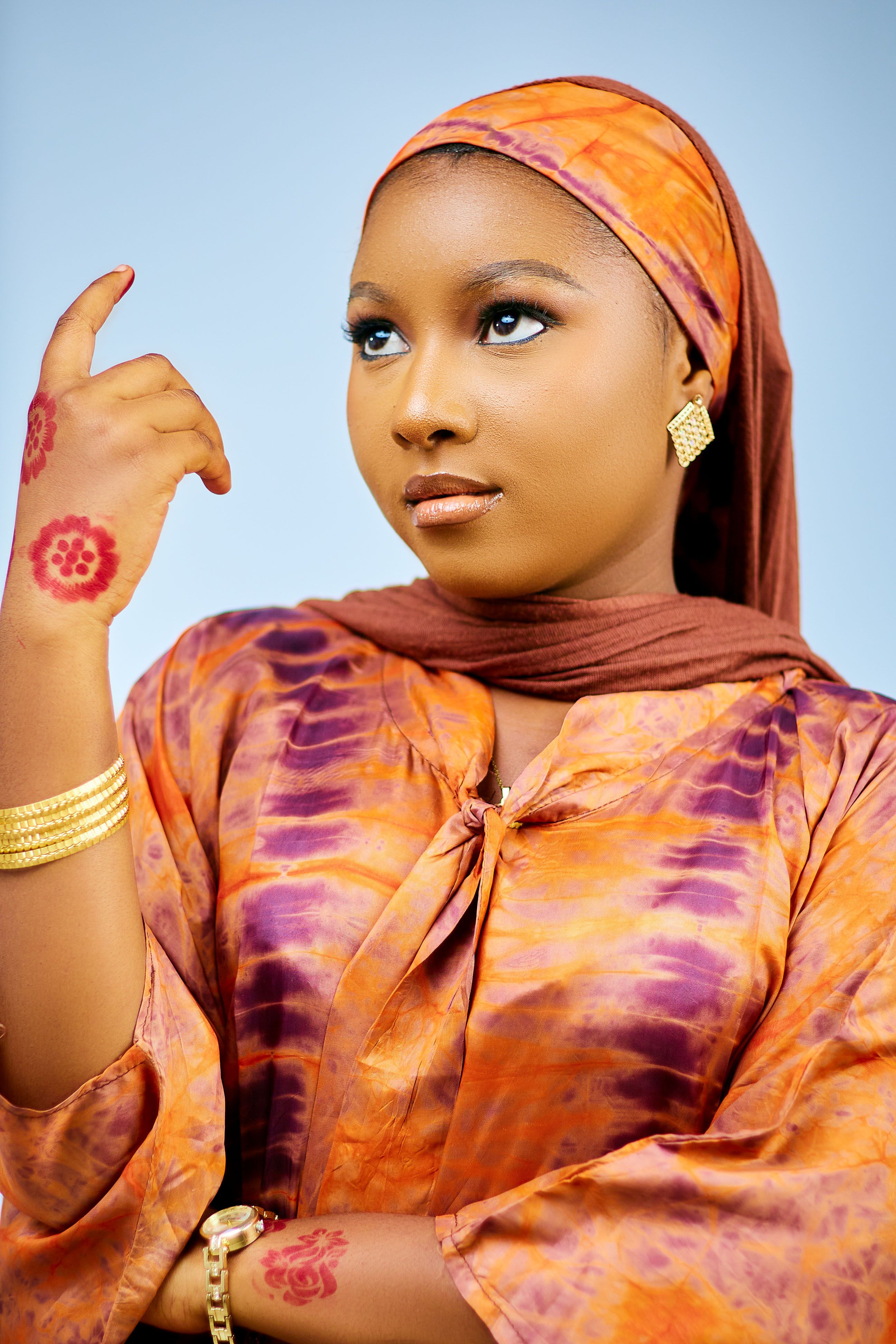 Portrait of a woman wearing colorful traditional attire with henna designs, exuding elegance and confidence.