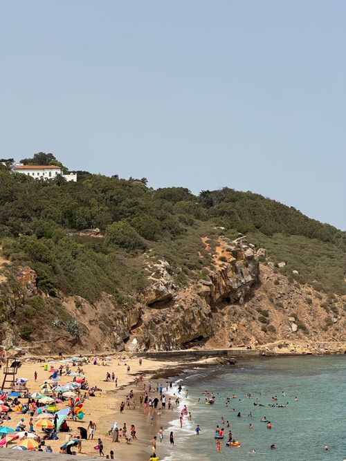 Free Crowded beach in Tangier, Morocco with cliffs and greenery in summer. Stock Photo