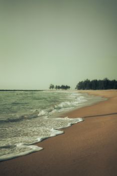 Peaceful beach scene with gentle waves and a sandy shore, perfect for travel inspiration.