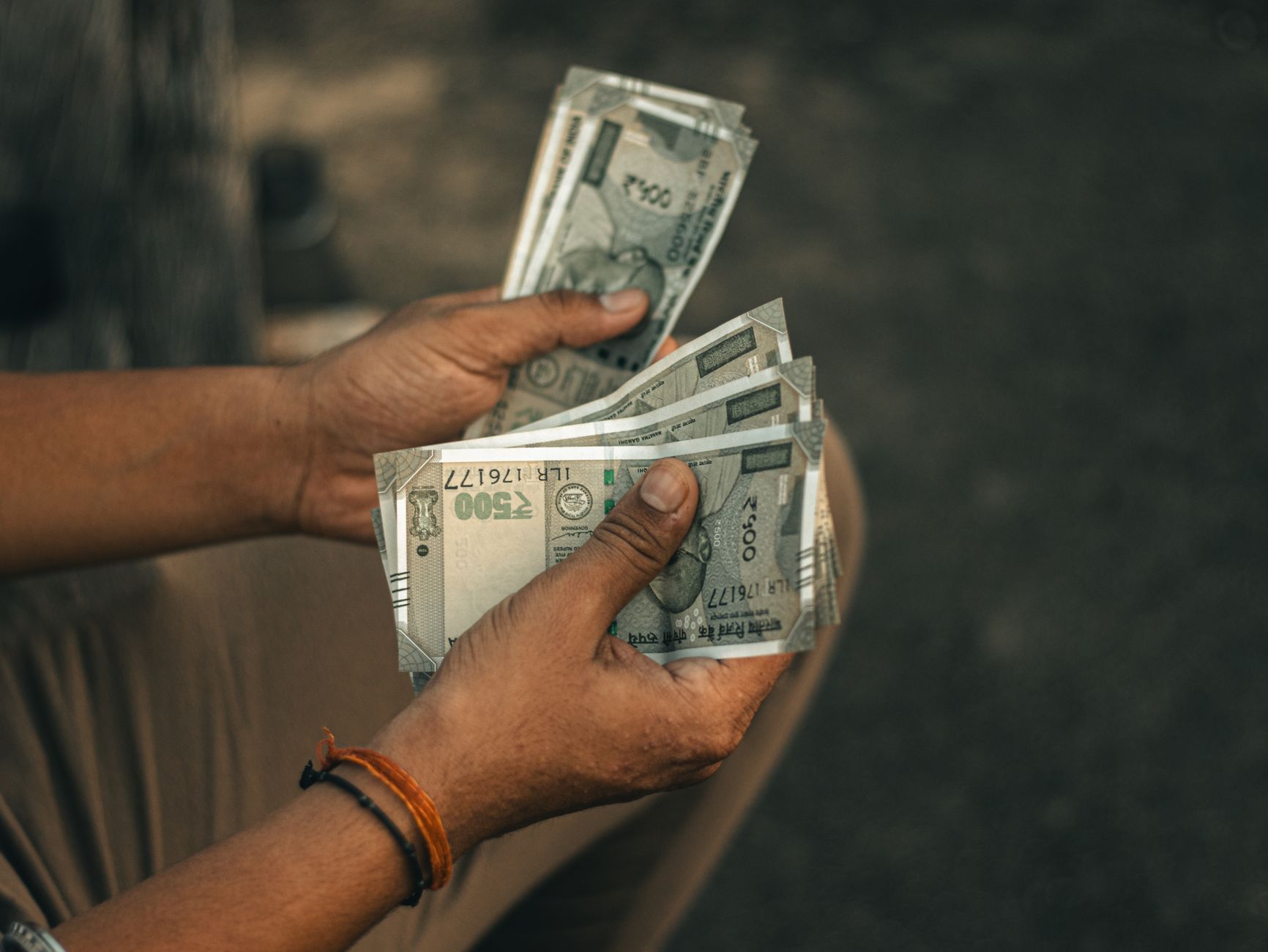 Small Indian business owner accepting Digital Rupee payment on a mobile device at a market stall