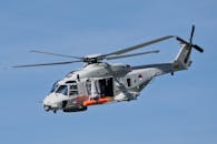 Military Helicopter in Flight Against Blue Sky