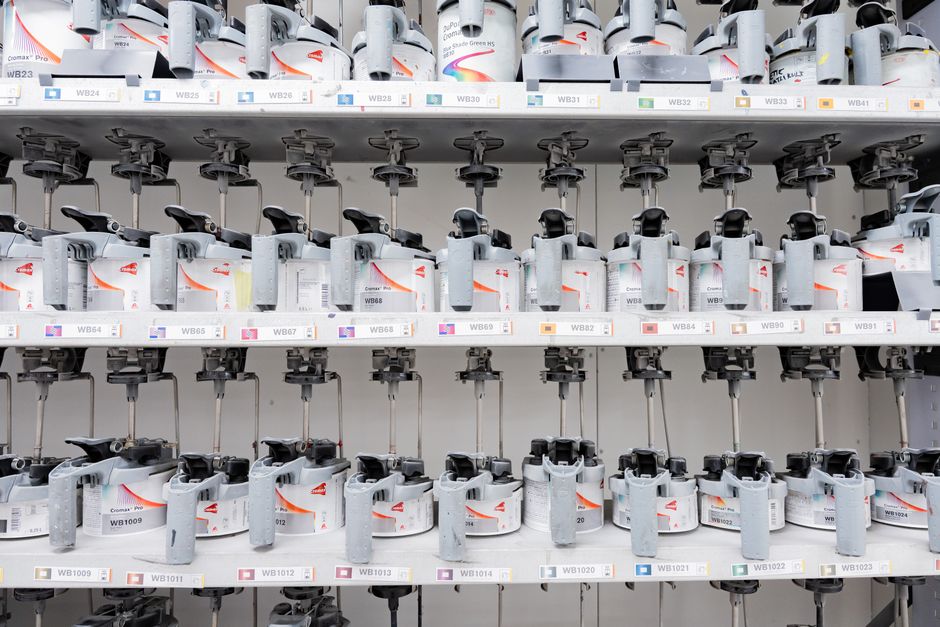 Organized industrial paint mixer station with multiple dispensers for accurate color mixing.