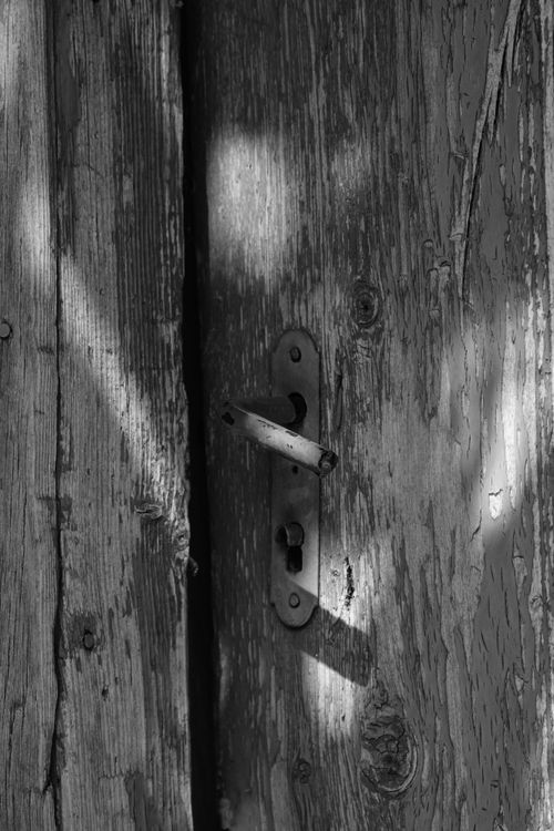 Free Rustic wooden door with vintage handle in a black and white photograph highlighting texture. Stock Photo