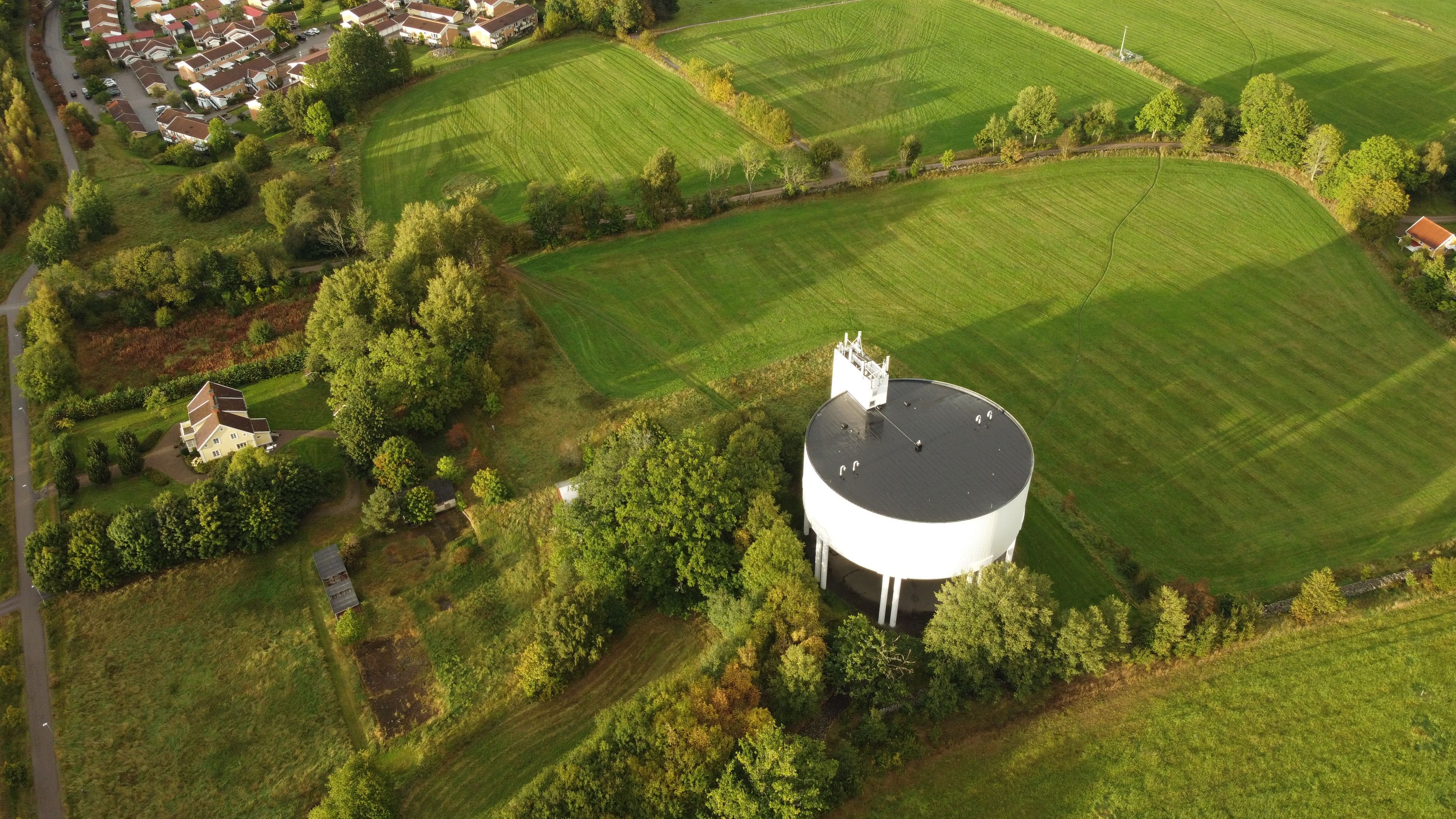 Aerial View of Water Tower in Lush Green Landscape · Free Stock Photo