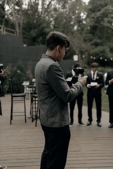 Photographer capturing moments at an elegant outdoor event with attendees dressed in formal attire.