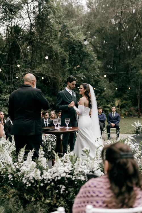 Free Bride and groom exchange vows outdoors, decorated with flowers. Elegant wedding scene. Stock Photo