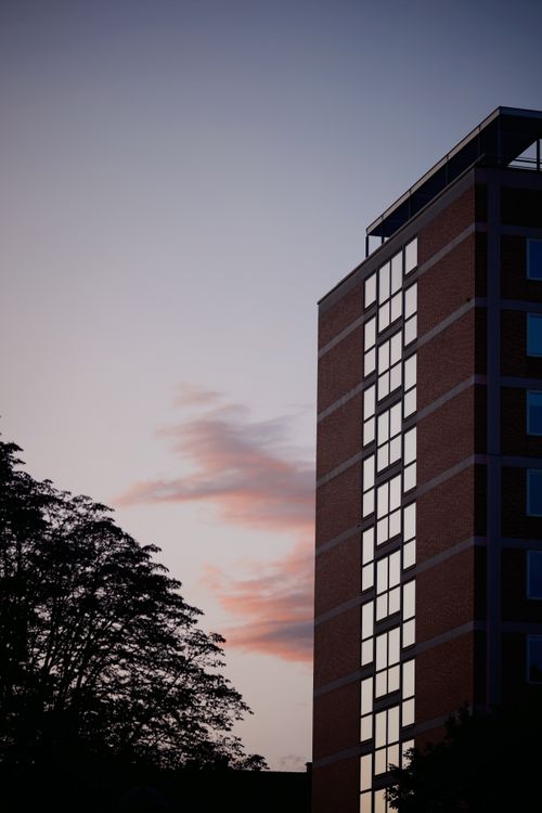 Free A contemporary urban building with reflective windows at dusk, highlighting city architecture. Stock Photo