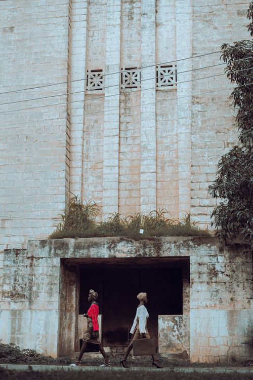 Urban Scene with Two People Walking Past Building · Free Stock Photo