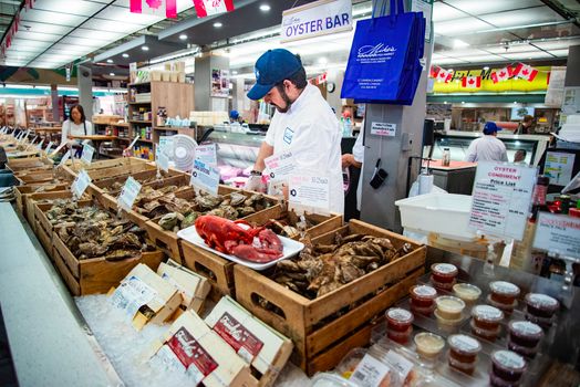 Busy seafood market featuring oyster bar, fresh seafood, and diverse options, vibrant atmosphere.