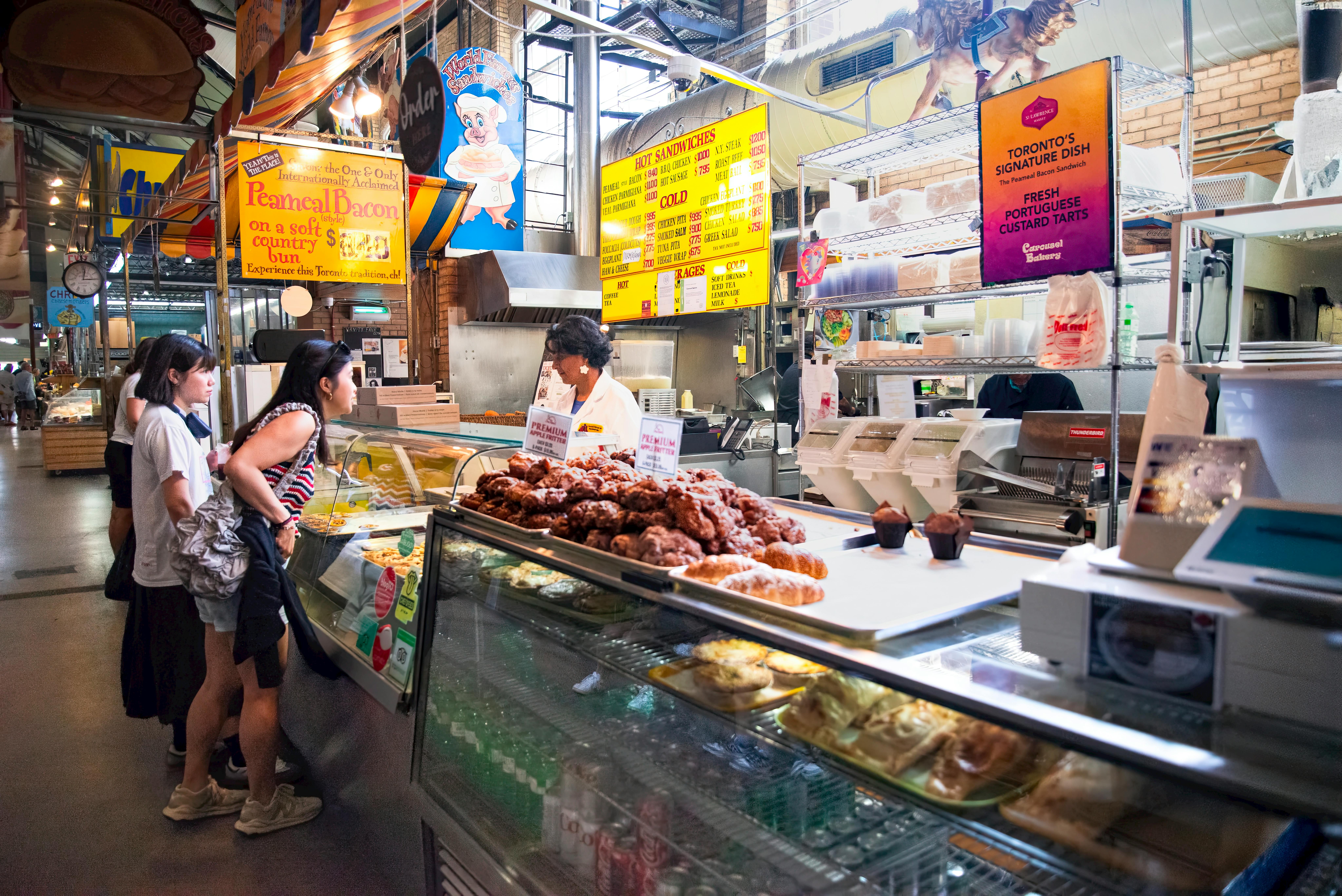 Visitors at St. Lawrence Market, Toronto, enjoying a variety of food delights and local specialties.