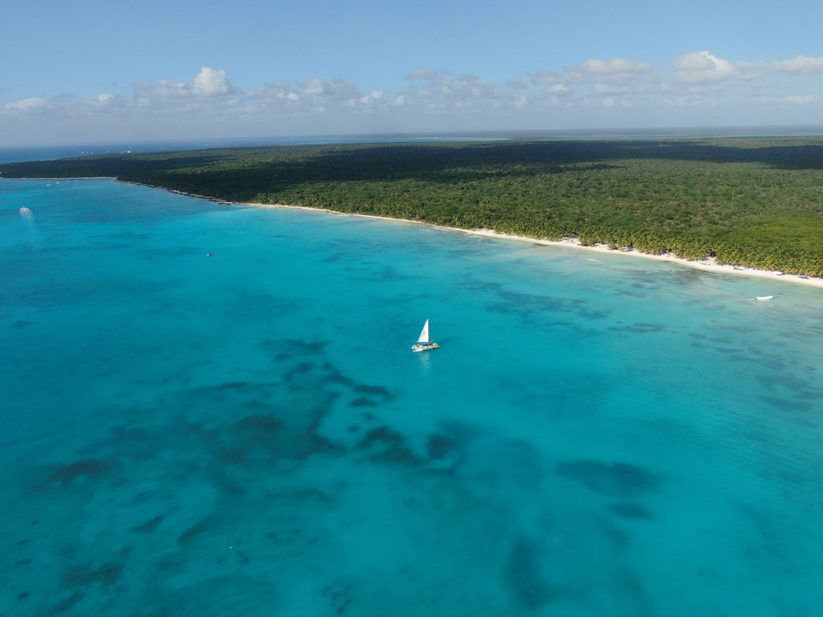 Vista aérea impresionante de un velero deslizándose sobre las aguas turquesas cristalinas